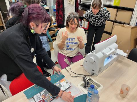 Photo de cinq personnes réunies autour d’une brodeuse numérique