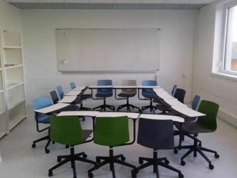 Photo de la salle Cré'Apprendre illustrant la modularité de l'espace : les chaises sur roulettes sont munies de table et placées en carré